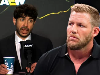 Tony Khan am Mikrofon und Jake Hager schaut zu ihm