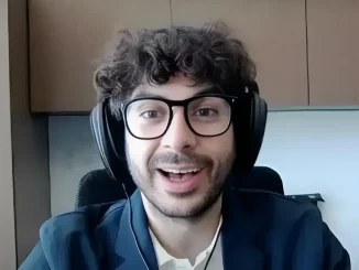 Tony Khan lächelt und trägt Kopfhörer