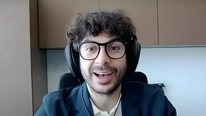 Tony Khan lächelt und trägt Kopfhörer