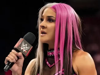 Dakota Kai hält ein WWE Mikrofon in der rechten Hand