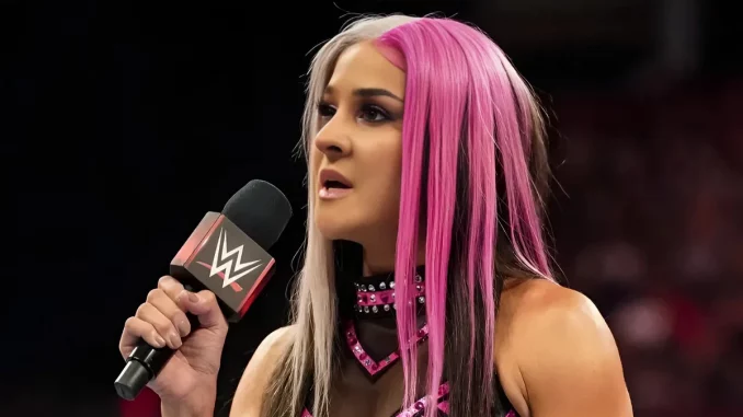 Dakota Kai hält ein WWE Mikrofon in der rechten Hand