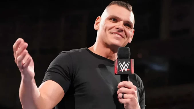 wwe-gunther-belächelt-fans Gunther hält lachend eine Rede im Ring