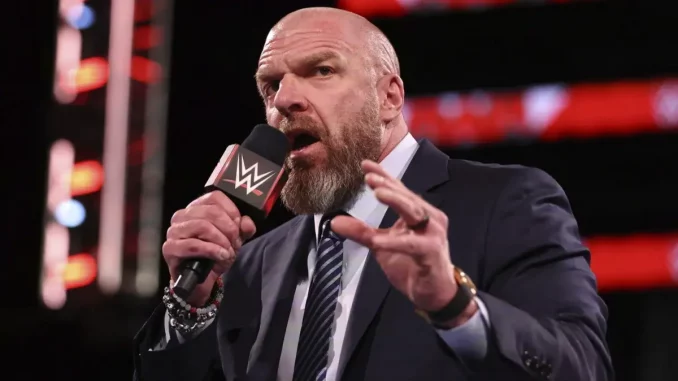 wwe-triple-h-mit-fan-botschaft Triple H steht im Ring und liefert eine Erklärung