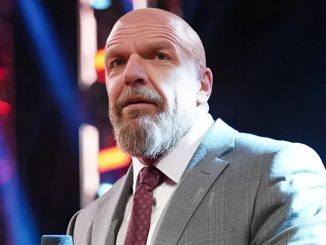 Triple H steht im Anzug im Ring