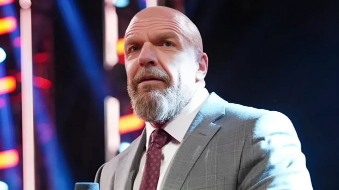 Triple H steht im Anzug im Ring