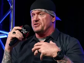 The Undertaker greift sich sitzend an seine Brust