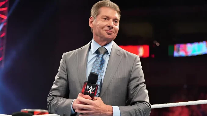 Vince McMahon steht grinsend im WWE Ring