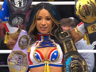 Mercedes Mone triumphiert mit vier Titeln im Ring und blickt in die Führungskamera.