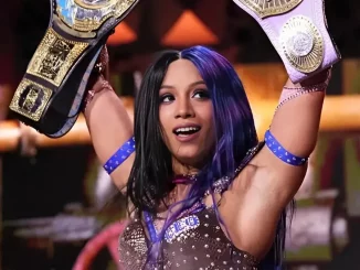 Mercedes Mone triumphiert mit zwei ihrer Womens Championship Belts auf der Stage