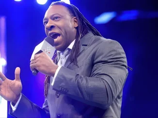 Booker T steht im Ring und spricht in ein Mikrofon