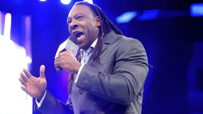 Booker T steht im Ring und spricht in ein Mikrofon