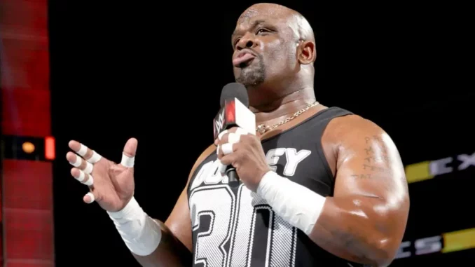 D-Von Dudley steht im Ring und hält das WWE-Mikrofon für seine Rede in der linken Hand