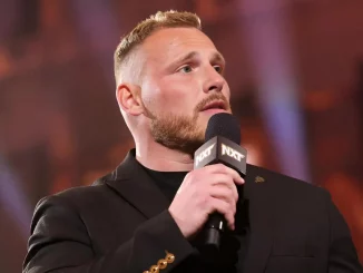 Ridge Holland hält ein WWE NXT Mikrofon in der rechten Hand