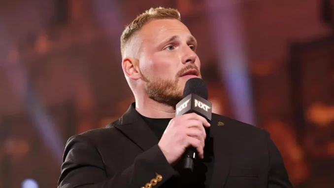 Ridge Holland hält ein WWE NXT Mikrofon in der rechten Hand
