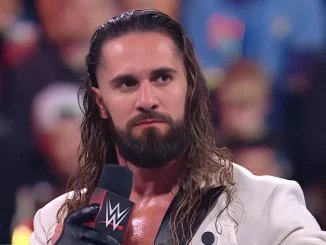 Seth Rollins steht im Ring, hält ein Mikrofon in der Hand und blickt in die Zuschauermenge