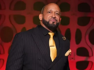 MVP steht lächelnd und im Anzug auf der AEW Stage