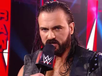 Mit ernstem Blick hält Drew McIntyre ein WWE-Mikrofon fest und spricht