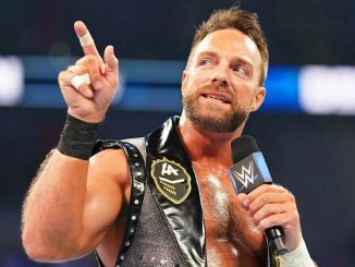 LA Knight streckt seinen rechten Zeigefinger in die Höhe und spricht ins Mikrofon