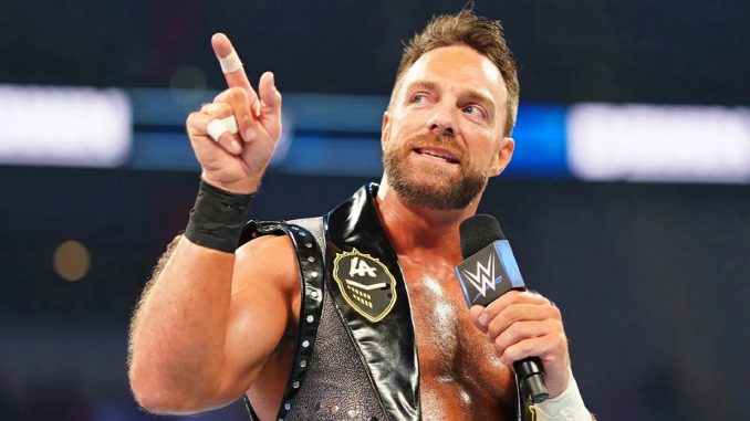 LA Knight streckt seinen rechten Zeigefinger in die Höhe und spricht ins Mikrofon