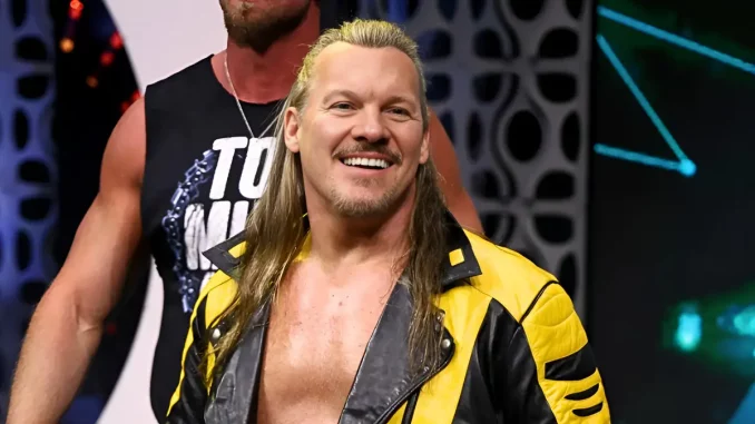 Chris Jericho steht lächelnd im gelb-schwarzen Outfit auf der Bühne