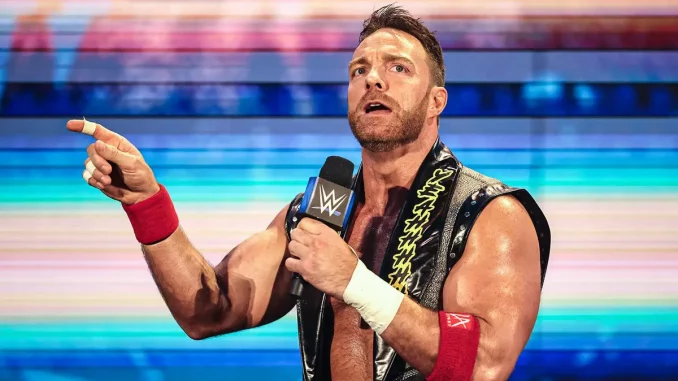 LA Knight steht mit einem WWE Mikrofon auf der Stage und streckt seinen Finger aus