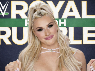 Tiffany Stratton lächelnd vor dem Royal Rumble Logo