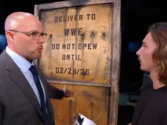 Adam Pearce und ein WWE-Mitarbeiter vor einer geheimnisvollen Kiste