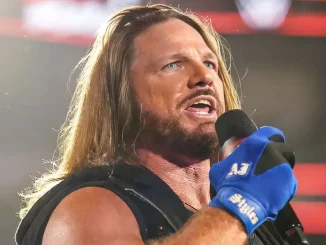 AJ Styles steht im Ring und hält für eine Rede ein Mikrofon in der Hand