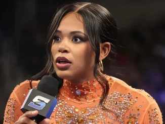 Bianca Belair hält ein Mikrofon der WWE in der Hand und ist erstaunt