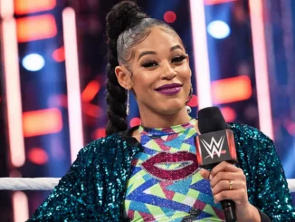 Biance Belair steht gut gelaunt mit einem WWE Mikrofon im Ring