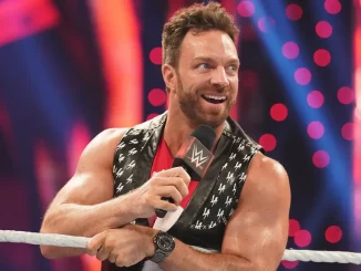 LA Knight steht mit einem Mikrofon der WWE am Ring und freut sich
