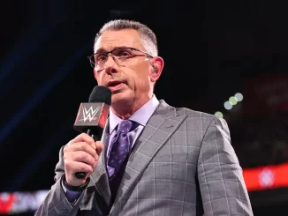 Michael Cole steht mit dem Mikrofon der WWE im Ring
