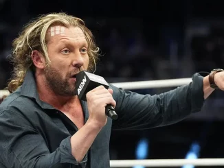 Kenny Omega deutet mit dem Finger auf den Ringboden
