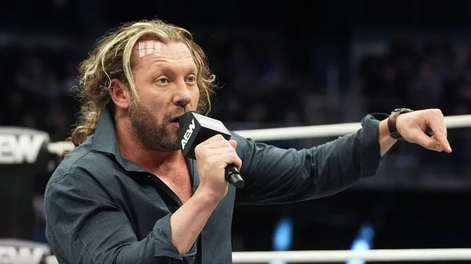 Kenny Omega deutet mit dem Finger auf den Ringboden