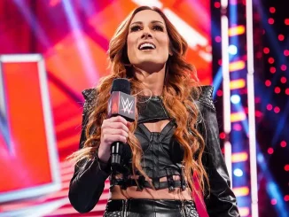 Becky Lynch hält ein WWE-Mikrofon in der Hand und lächelt