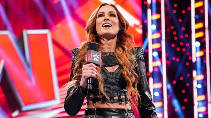 Becky Lynch hält ein WWE-Mikrofon in der Hand und lächelt