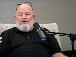 Road Dogg sitzt am Mikrofon und äußert sich