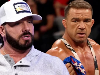 AJ Styles spricht und Chad Gable hält im Hintergrund eine Maske in der Hand