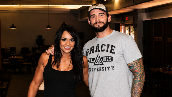 CM Punk legt seine Hand auf die Schulter von Layla ab