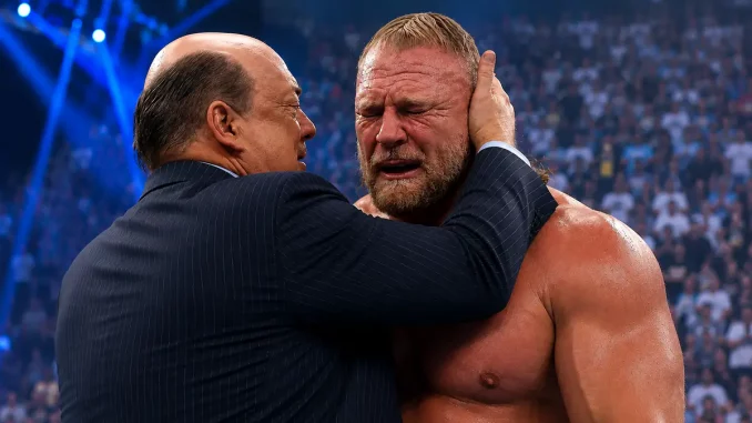 Paul Heyman steht im Ring und hält Brock Lesnars Kopf