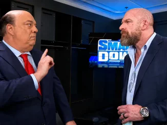 Paul Heyman erhebt seine Hand gegenüber Triple H im Backstagebereich