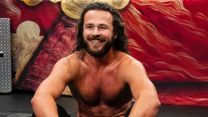 Jack Perr sitzt lachend vor dem AEW Ring