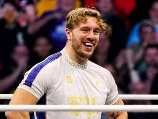 Will Ospreay steht gut gelaunt und leicht lächelnd im Ring