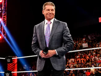Vince McMahon steht lächelnd im WWE Ring