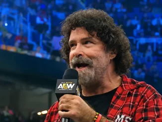 Mick Foley steht im Ring und spricht begeistert ins AEW-Mikrofon