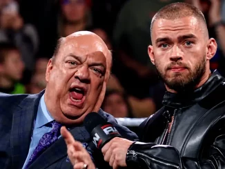 Paul Heyman im Anzug spricht lautstark in ein Mikrofon, während Austin Theory mit schwarzer Lederjacke ernst danebensteht
