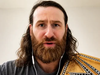 Sami Zayn trägt während seines Interviews weiße Kopfhörer und den Undisputed WWE Champion Titel