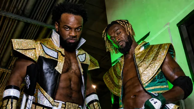 Kofi Kingston und Austin Creed halten sich im Backstagebereich auf und blicken in die Kamera