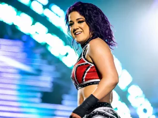 Bayley steht lachend im Ring und schaut dabei ins Publikum