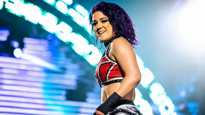 Bayley steht lachend im Ring und schaut dabei ins Publikum